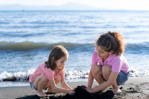 istock Children playing with sand by the sea. 2172135335