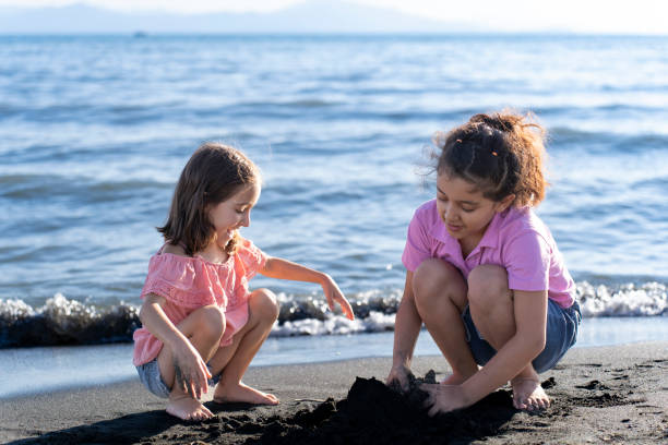 istock Children playing with sand by the sea. 2172135336
