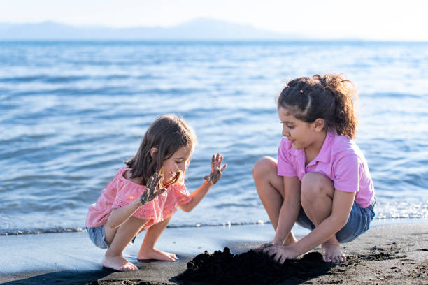 istock Children playing with sand by the sea. 2172135436