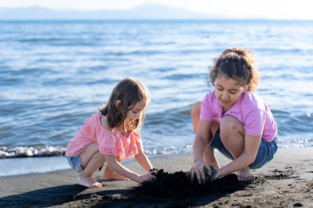 istock Children playing with sand by the sea. 2172135556