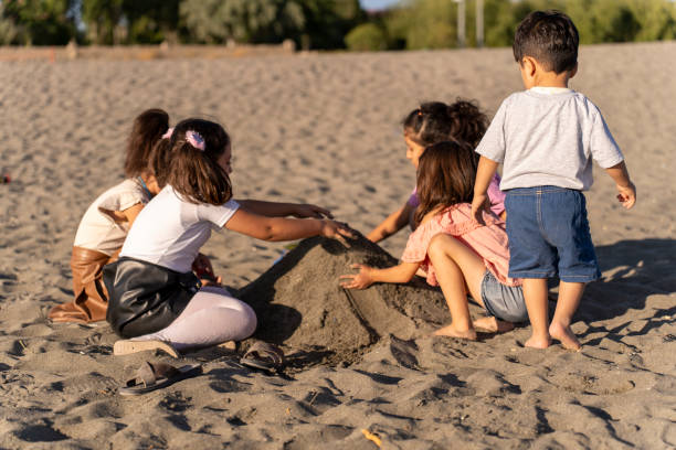istock Children playing with sand by the sea. 2172135987