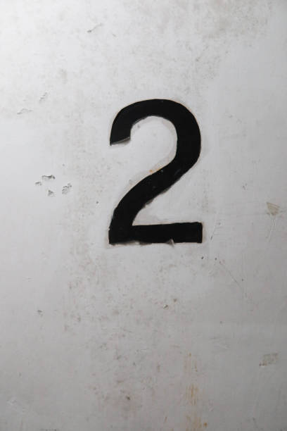 istock close up of black number two (2) painted on the white wall 2172136164
