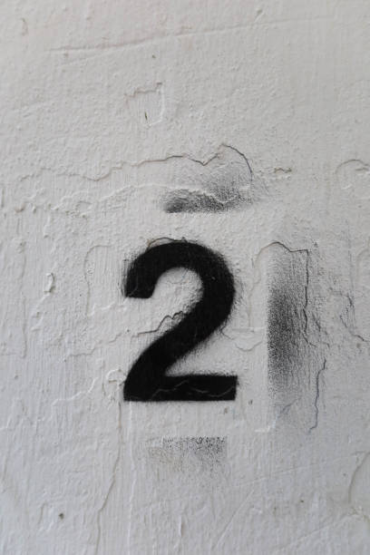 istock close up of black number two (2) painted on the white wall 2172139157