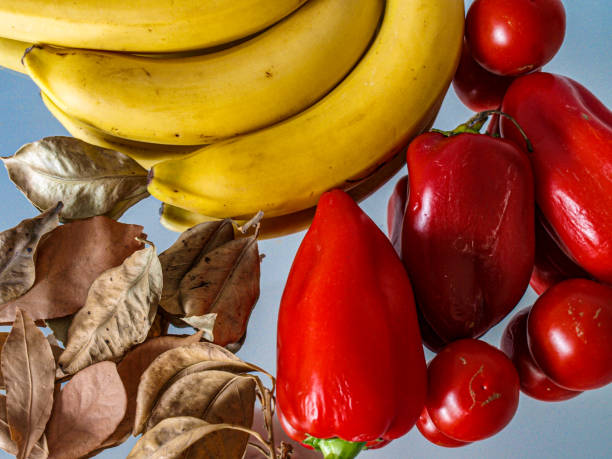 Yellow bananas red peppers and dry foliage