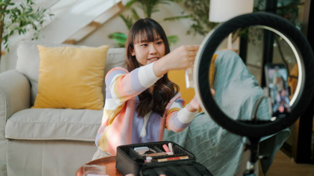 young asian woman recording a video review of a cosmetic product at home. - để làm gì hình ảnh sẵn có, bức ảnh & hình ảnh trả phí bản quyền một lần