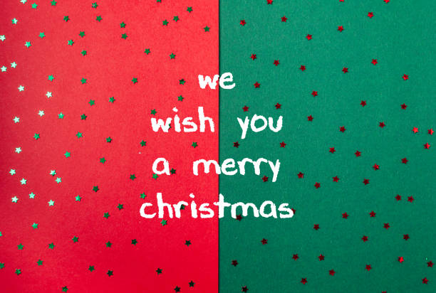 A red and green background with stars and the words We wish you a Merry Christmas written in white