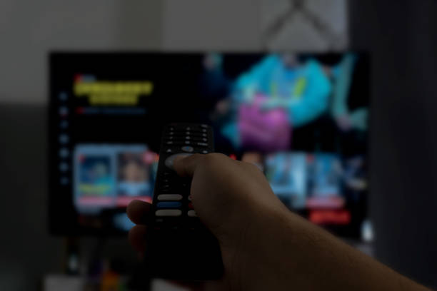 istock Hand Holding Use Remote Control and Watching TV in House with relaxing atmosphere. 2172156873