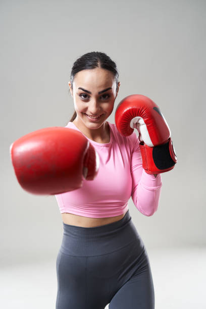 istock Woman boxer in red gloves on gray 2172165548