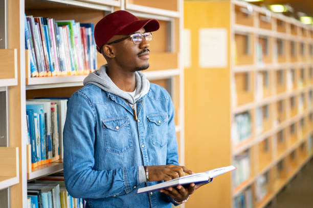 istock Male scholar reading in a library 2172167970