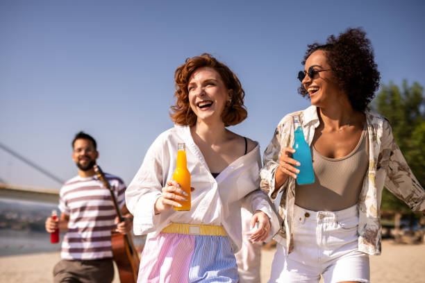 istock Two friends hanging out on the beach and drink coctails. 2172168466