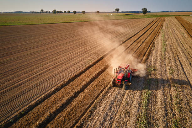 istock Tractor working in agricultural field, cultivating and plowing dry soil 2172170784