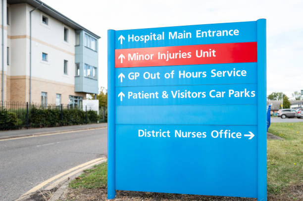 Large, NHS type information sign showing outpatients department, out of hours doctors and a minor injury unit. stock photo