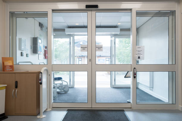 automatic doors seen at the exit of an nhs outpatients department in a busy british hospital. - hospital entrada fotografías e imágenes de stock