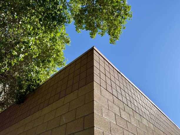a corner view of a brown-painted block exterior building wall, showcasing its textured surface and sharp angles, offering a glimpse of urban architecture and simple design