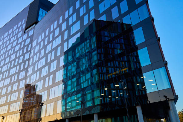 istock Modern glass office building reflecting city skyline at sunset 2172172016