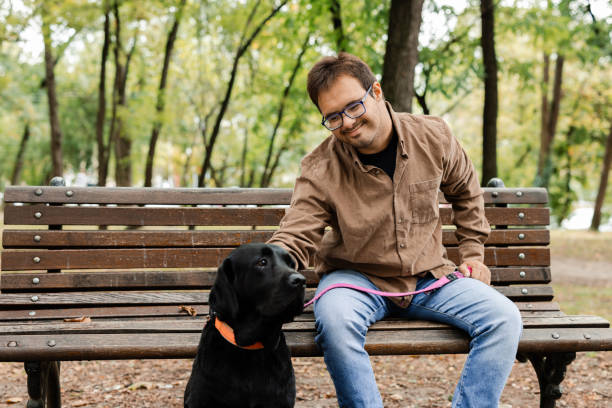 istock Man with Down syndrome bonding with his dog in the park 2172179985