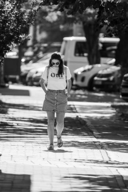Timisoara, Romania - August 05, 2024: Woman walking on the street. Real people. Black and white.