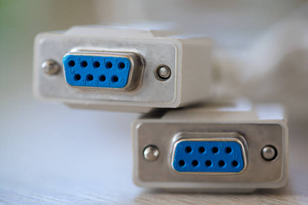 Close-up of a RS-232 serial port. Female to female extension cord on a wooden table.