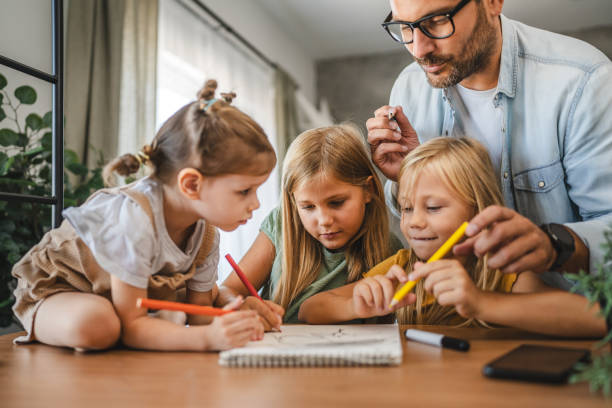 istock Adult single father of three daughters help them to do homework 2172183064