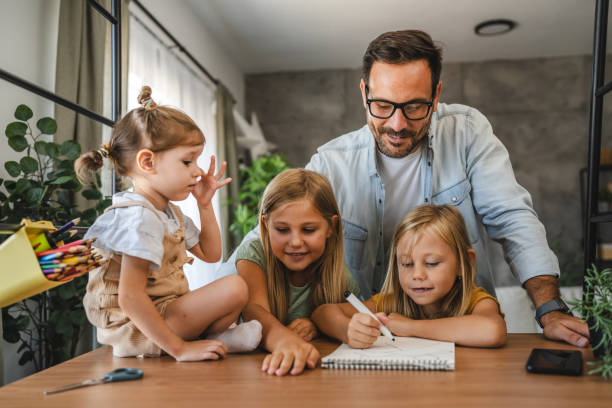 istock Adult single father of three daughters help them to do homework 2172183102
