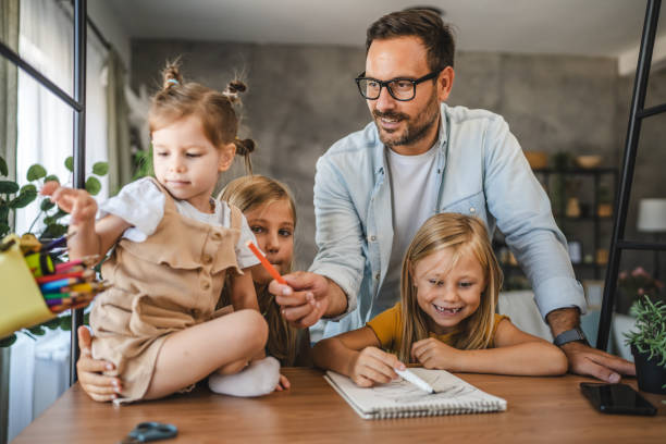 istock Adult single father of three daughters help them to do homework 2172183234