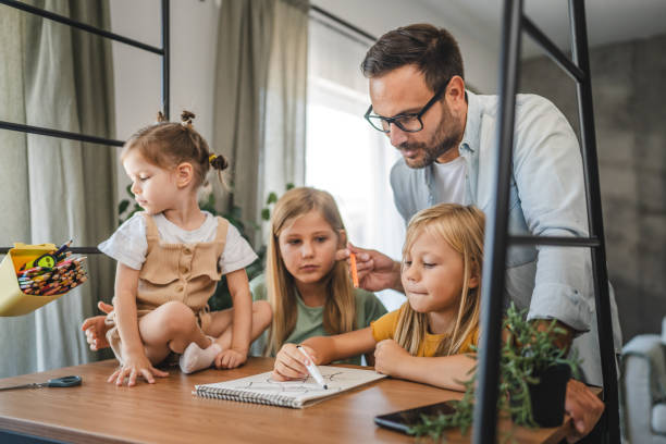 istock Adult single father of three daughters help them to do homework 2172183247