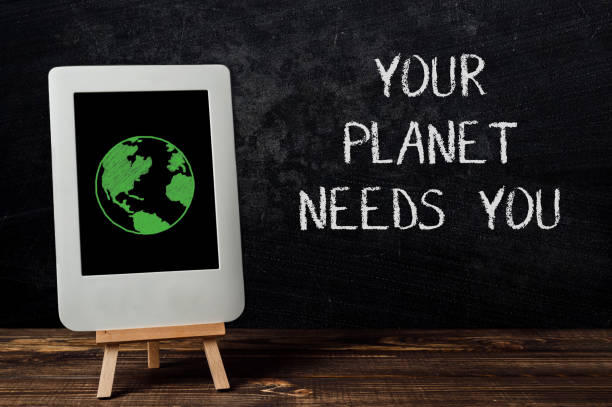 istock A tablet with a green planet on it is on a wooden table 2172183701