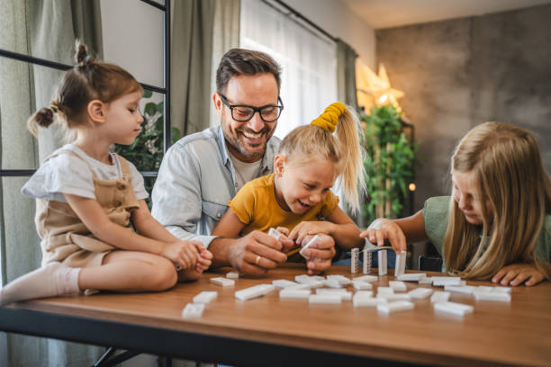 istock Single father play dominoes with his three young daughters at home 2172184089
