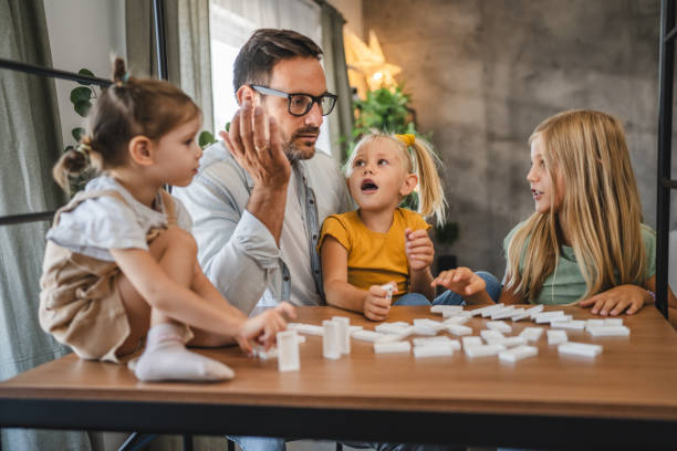istock Single father play dominoes with his three young daughters at home 2172184397
