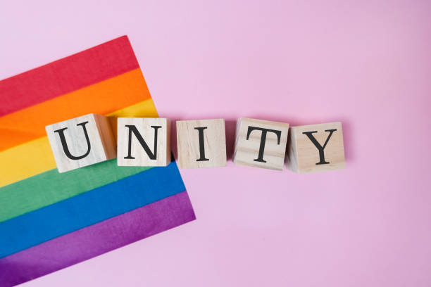 istock A rainbow flag and a wooden block with the word unity written on it 2172185566