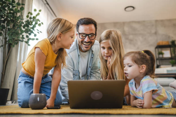 istock Father and three daughters enjoy time together with a laptop screen 2172189260