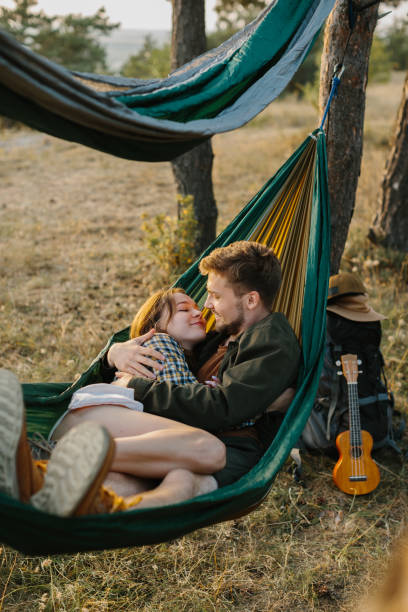 istock Couple in love hugging in a hammock at sunset in a pine forest. 2172189528