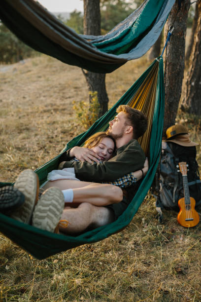 istock Couple in love hugging in a hammock at sunset in a pine forest. 2172189532