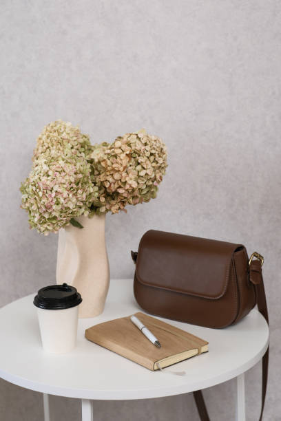 istock Chic Workspace Setup Featuring a Stylish Bag, Great Coffee, and Beautiful Floral Decor 2172189637