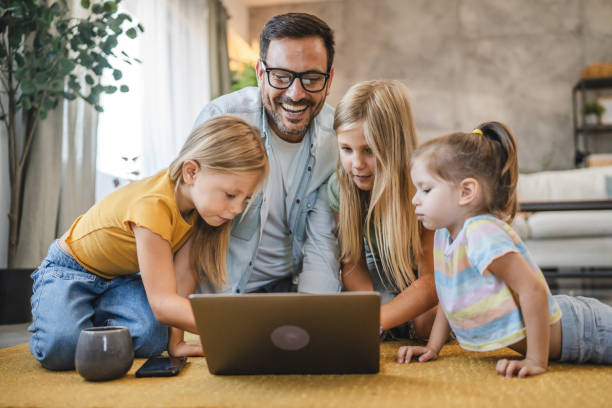 istock Father and three daughters enjoy time together with a laptop screen 2172189878