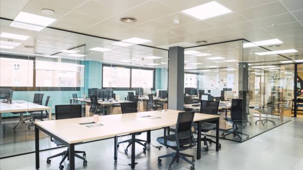 istock Interior of spacious creative coworking workspace with desks and chairs in glass cabins 2172199050