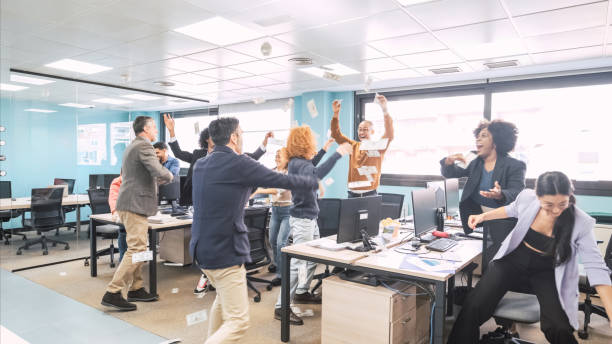 istock Cheerful businesspeople reaching for currency notes thrown by managers at office 2172199298