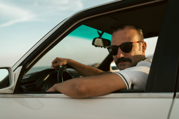 istock Man Driving on a Coastal Road at Sunset 2172203652