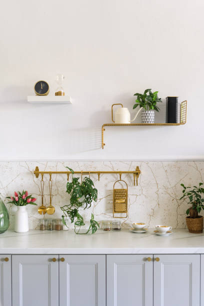 istock Modern kitchen with pastel cabinets and decorative plants, featuring a marble backsplash and elegant kitchenware 2172208488