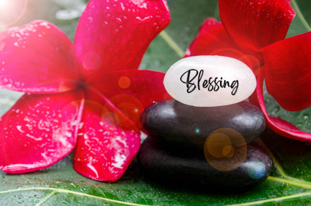 istock Blessing text engraved on white zen stones with zen flower and shining light background 2172223900