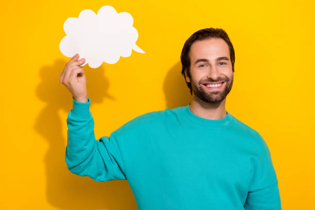 istock Photo of cute cheerful guy dressed teal outfit smiling mind speaking cloud empty space isolated yellow color background 2172237111