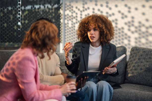 istock Diverse team on couch collaborating on project in office lobby. 2172254126