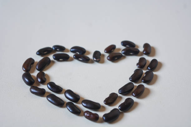 Heart-shaped black bean seeds on a white background.