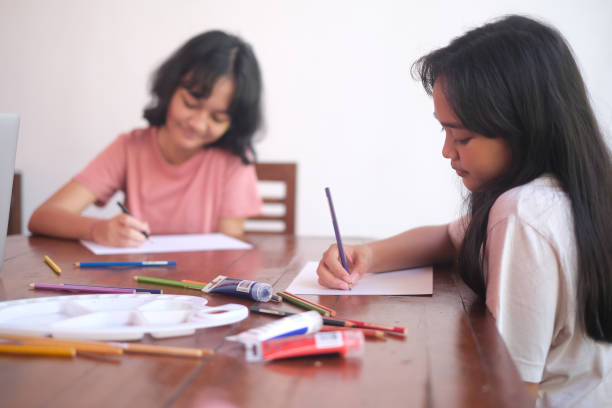 istock Two Sisters Drawing Together at Home 2172266546