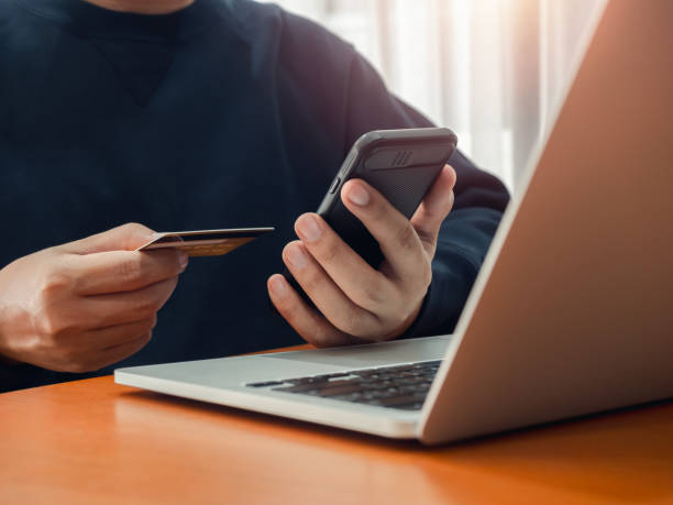 istock Secure payment concept. Black smart mobile smart phone in businessman hand while holding credit card for checking payment, online shopping, exchange or money transfer by finance application. 2172273874