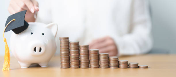 istock Money saving for Education, Scholarship, Student loan and debt and study future plan concept. Coins stack growing up with piggy and graduation hat on table 2172275334