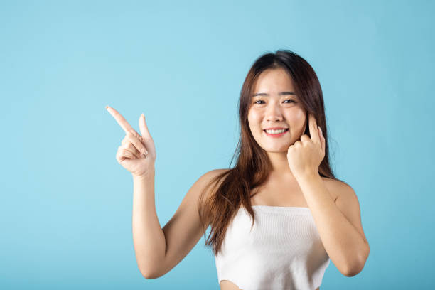 istock Asian beautiful young woman finger pointing to empty copy space 2172276637