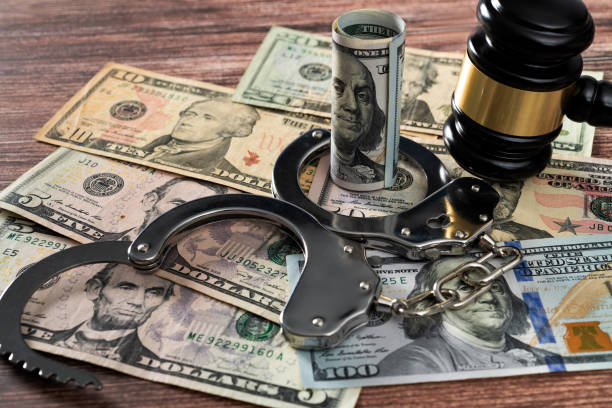 istock Gavel and handcuffs on stack of US paper currency 2172278263