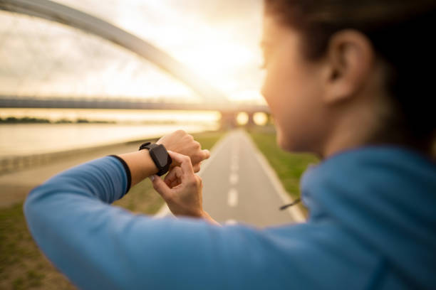 istock Athletic woman looking at smart watch while exercising outdoors in the morning. 2172289272