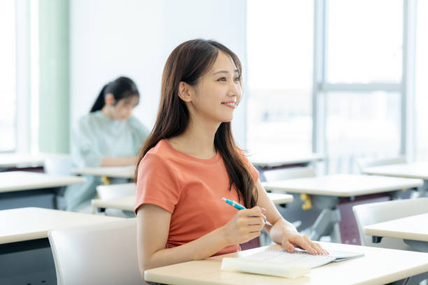 female university student taking classes in the classroom - 学ぶ ストックフォトと画像